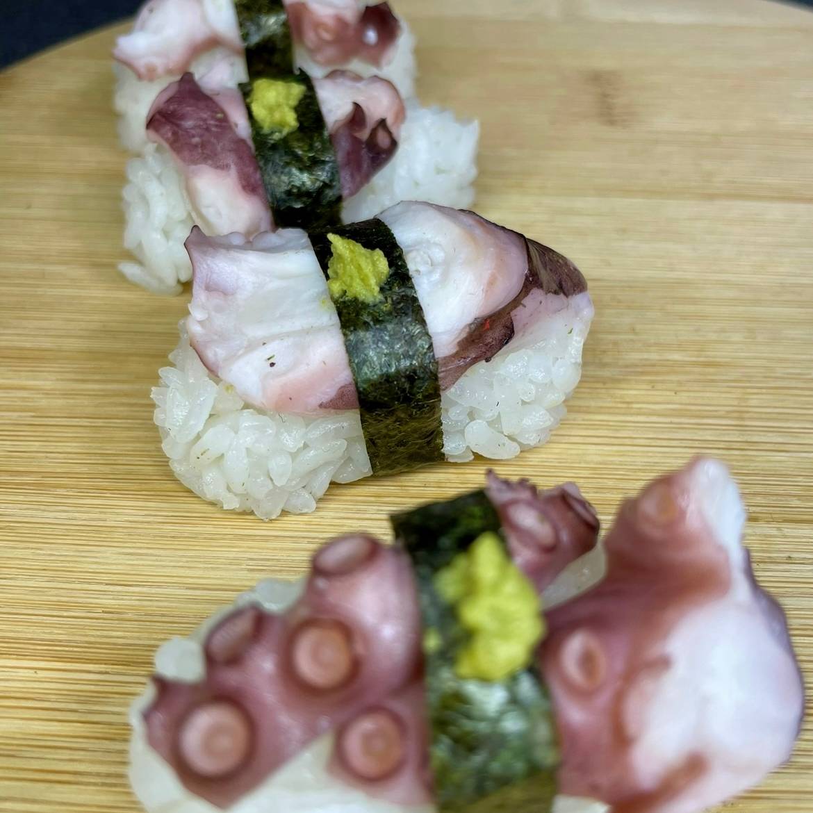 Tako nigiri ar astoņkāja gabala, rīsiem un jūraszāļu lentītes