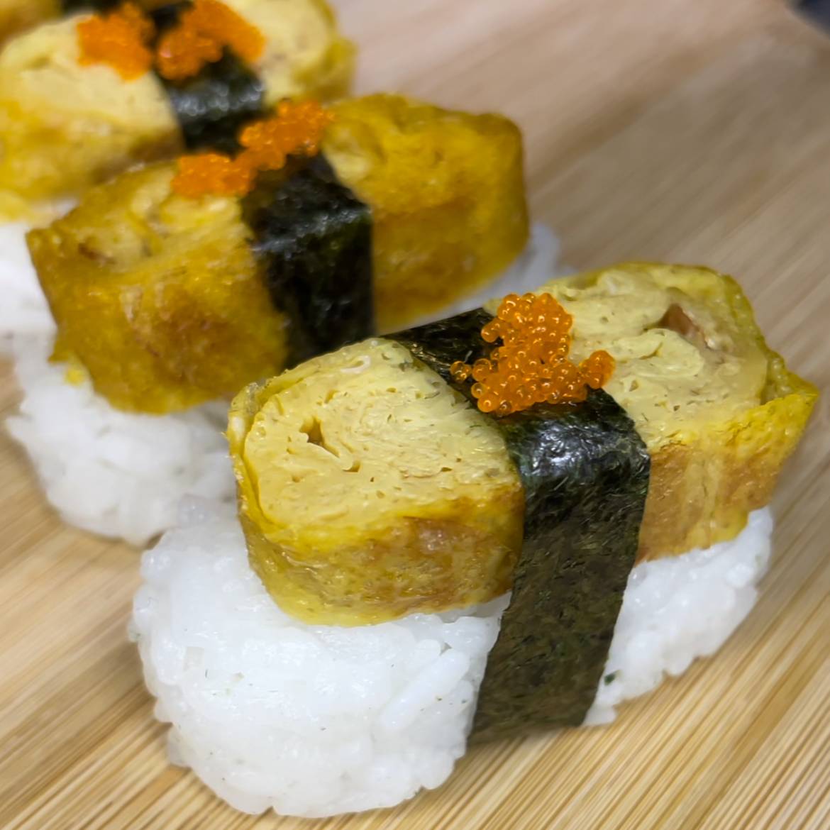 Tamago nigiri ar saldo japāņu omleti, rīsiem, jūraszālēm un ikriem virspusē